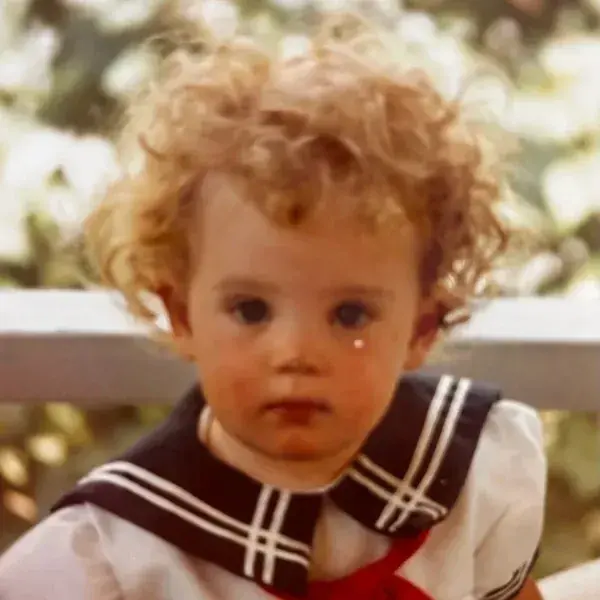 A young child wearing sailor 's outfit and looking at the camera.