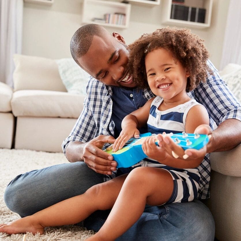 A man and child sitting on the floor.